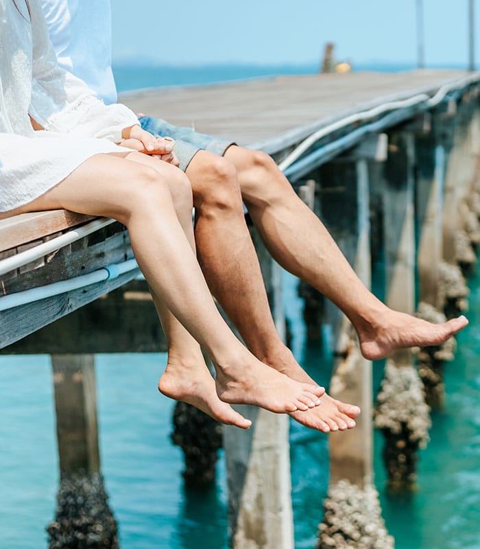 a person sitting on a dock next to a body of water